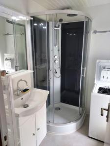 ein Bad mit einer Dusche und einem Waschbecken in der Unterkunft SCIOTOT-BORD DE MER - LA GRANGE in Les Pieux