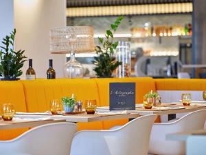 un restaurante con mesas, sillas y botellas de vino en ibis Styles La Roche-sur-Yon, en Mouilleron-le-Captif