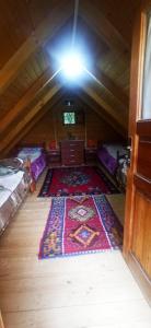 an attic room with a rug on the floor at Velemun brvnara in Plav