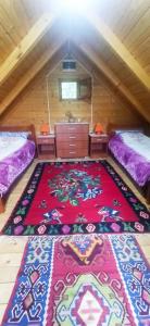 a room with two beds and a rug on the floor at Velemun brvnara in Plav