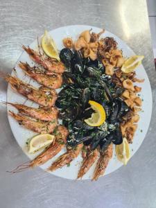 a plate of shrimp and vegetables with lemon slices at Hotel RR in Herceg-Novi
