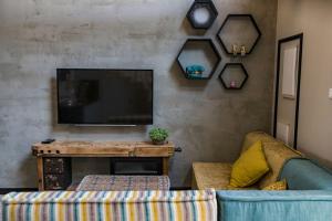 a living room with a couch and a television at Gold 68 in Kefar Barukh