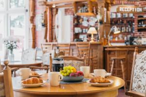 una mesa con platos de comida en un restaurante en Villa Bachmann - Kuršių kiemas, en Juodkrantė