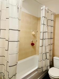 y baño con bañera, aseo y cortina de ducha. en Dream Sury Apartment - metrou Leonida, spital Obregia, en Bucarest