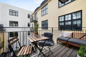 哥本哈根的住宿－Boutique apartment in Citycenter，阳台配有长凳、桌子和沙发。