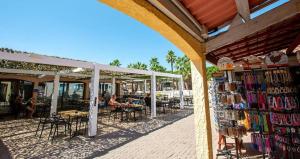 a group of people sitting at tables outside a store at 6/8 pax COTTAGE - Oasis Village in Puget-sur Argens