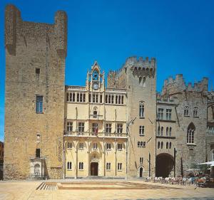 um grande castelo com uma torre de relógio em cima dele em petit paradis au soleil em Narbona