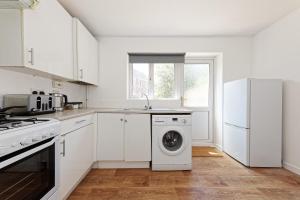a white kitchen with a washing machine in it at Comfortable Home in Kent, Sleeps 6 - Parking Available in Kent