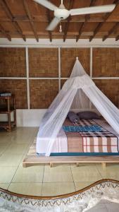 a bed in a room with a mosquito net at Enter Point in Bukit Lawang