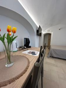 a dining room table with a vase of flowers on it at Nonna Cia in Gallipoli