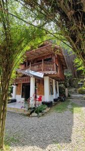 a house with a balcony and a tree at Enter Point in Bukit Lawang
