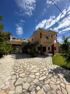 a house with a stone driveway in front of it at Hotel Odyssion in Vasiliki