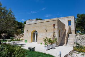 un edificio de ladrillo con escaleras y plantas en un patio en Antico Casolare P. P., en Otranto