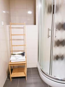 een badkamer met een douche en een houten kruk bij Apartment Jurčević in Trogir