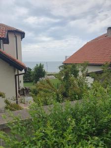 a view of the ocean from between two houses at студия ЛИЛИЯ in Tsarevo