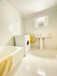 uma casa de banho branca com uma máquina de lavar roupa e um lavatório em Camelia Apartment em Nafplio