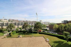 um parque com palmeiras em frente a um edifício em Apartamento frente al Sardinero em Santander