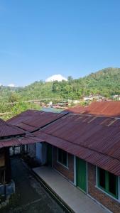 a row of roofs of houses with mountains in the background at Enter Point in Bukit Lawang