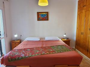 a bedroom with a bed with a red bedspread on it at Luxurious Carabeo 2000 1.3 in Nerja