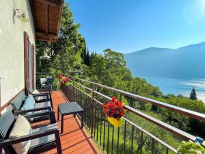 a balcony with two chairs and a pot of flowers at Appartamento Tivano balcone con vista lago in Bellagio
