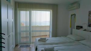 1 dormitorio con cama y ventana grande en Апартаменти Сънбрийз - Sunbreeze Apartments, en Byala