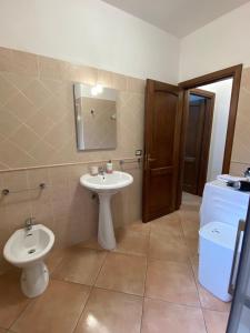 een badkamer met een wastafel, een toilet en een spiegel bij Casa Relax - Sas Murtas Posada in San Lorenzo