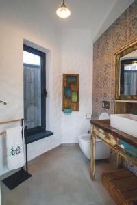 a bathroom with a sink and a toilet and a window at The Hut Retreat in Fîntînele