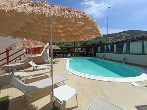 una piscina con sillas y sombrilla en Hotel Palladium en Monastir