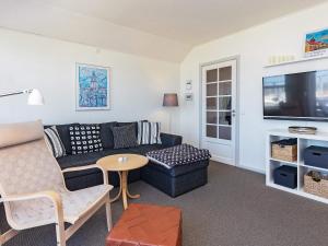 a living room with a couch and a tv at Holiday home Rudkøbing XX in Rudkøbing