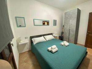 een slaapkamer met een groen bed met 2 handdoeken erop bij Casa Relax - Sas Murtas Posada in San Lorenzo