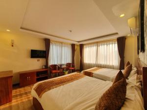 Habitación de hotel con 2 camas y escritorio en Nghiêng Sapa Hotel en Sa Pa
