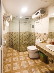 y baño con ducha, aseo y lavamanos. en Nghiêng Sapa Hotel en Sa Pa