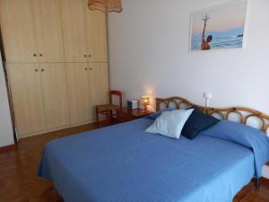 1 dormitorio con 1 cama con manta azul en Grazioso Bilocale Caletta Castiglioncello - Tuscany, en Castiglioncello