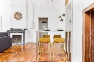a kitchen with a table and two yellow bar stools at Gambetta 302 CahorsCityStay in Cahors