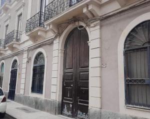 a building with a black door on a street at L&L House in Catania