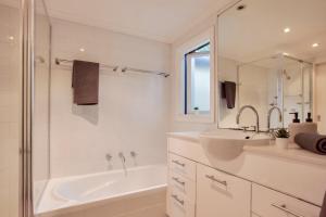 a white bathroom with a tub and a sink at 3 Bedrooms - Darling Harbour - Darling St 2 E-Bikes Included in Sydney