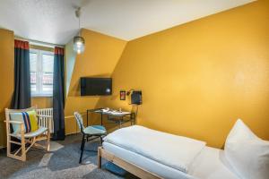 1 dormitorio con 1 cama, escritorio y TV en Vier Jahreszeiten en Würzburg