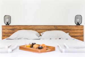 a bed with a wooden headboard and a tray of fruit at Gambetta 302 CahorsCityStay in Cahors