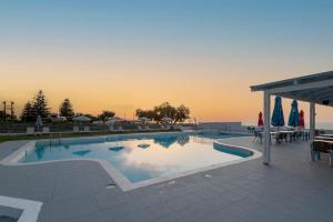 a swimming pool with a sunset in the background at Varvara's Diamond - Adults Only in Platanes