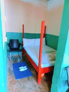 Habitación pequeña con litera y silla en Talanta Ajira Cottages en Kisumu
