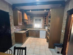 a kitchen with wooden cabinets and a tile floor at Chalet , a 6km de la playa in Chiclana de la Frontera