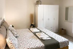 una camera da letto con un letto con asciugamani sopra di Casa storica con terrazzo a Castellina Marittima
