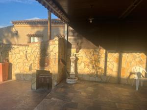 a stone wall with a fireplace in a patio at Chalet , a 6km de la playa in Chiclana de la Frontera