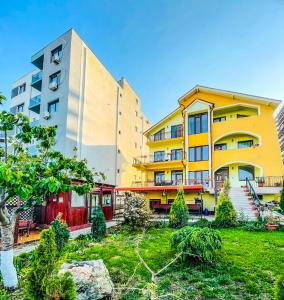 a group of buildings with a garden in front of it at Vila Orange in Mamaia Nord