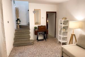 un soggiorno con scale e un tavolo con uno specchio di Casa storica con terrazzo a Castellina Marittima