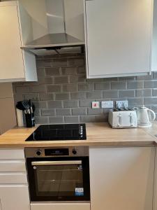 a kitchen with a stove and a counter top at Groups and Contractors - Newly Renovated 4-bed in Derby