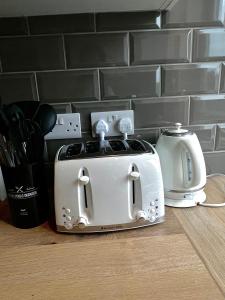 a white toaster sitting on top of a counter at Groups and Contractors - Newly Renovated 4-bed in Derby