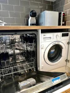a dishwasher with its dishes in it in a kitchen at Groups and Contractors - Newly Renovated 4-bed in Derby