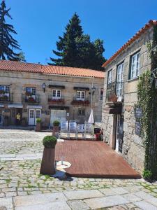 a building with chairs and a patio in front of it at Casa Terreiro Da Lapa in Quintela