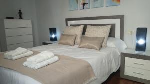 a bedroom with a white bed with two towels on it at Apartamento La Cava in Calahorra